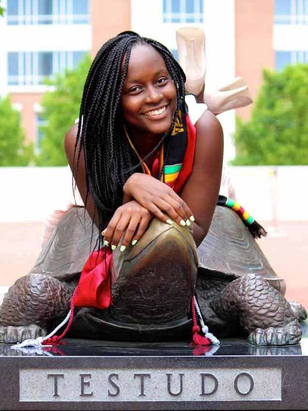 Rebecca Basena Kampi poses with graduation collar and Testudo