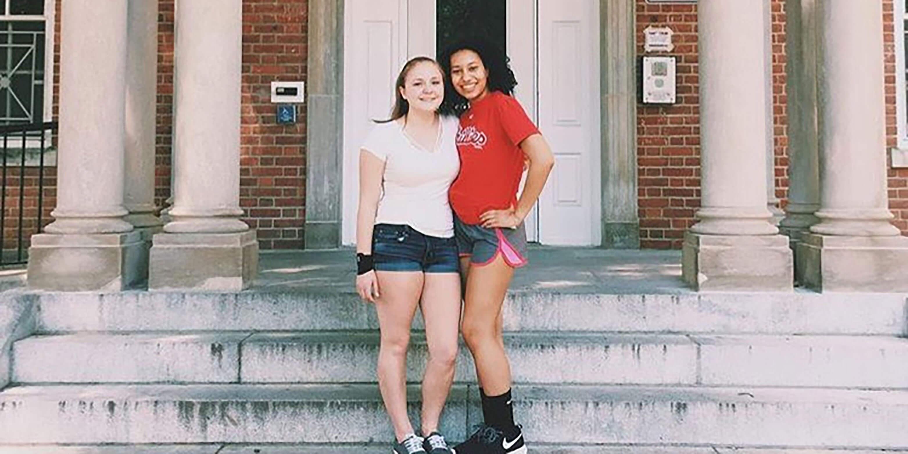 Two female students stand on the steps of Cumberland Residence Hall